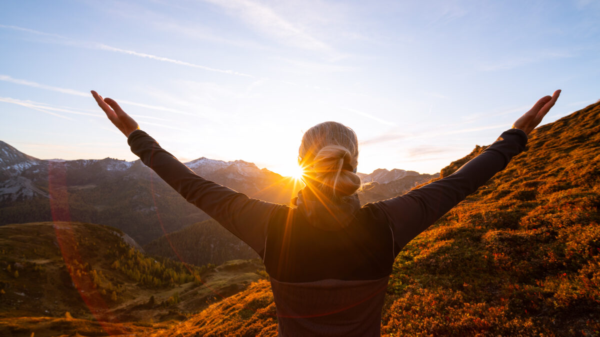 Breathwork Frau Sonnenaufgang Arme zeigen zum Himmel