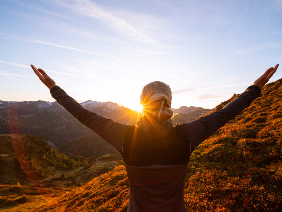 Breathwork Frau Sonnenaufgang Arme zeigen zum Himmel