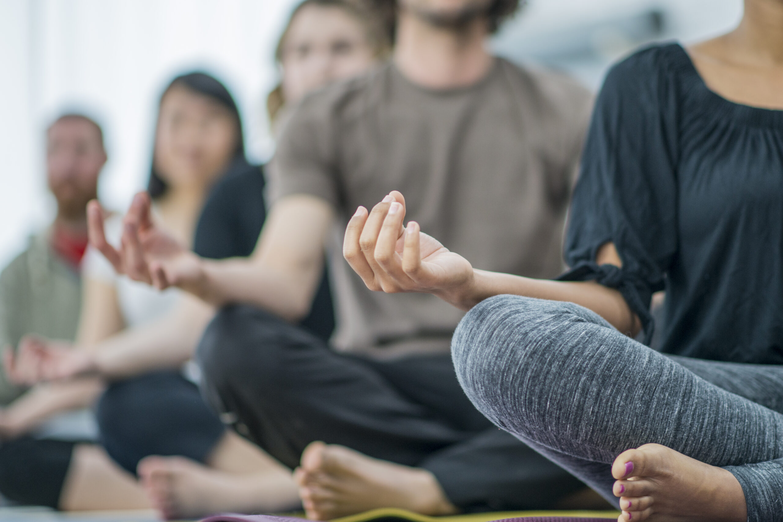MBSR Menschen hintereinander in Meditationssitz